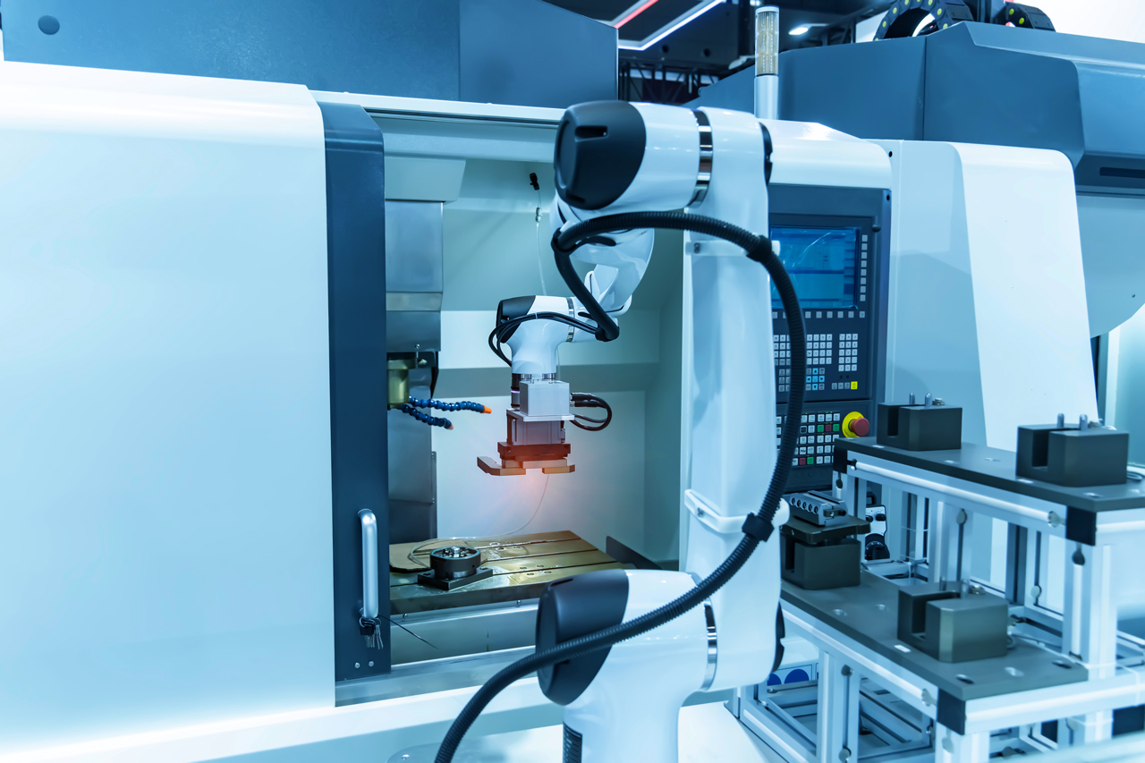 A photo of a industrial soldering station with a robotic arm